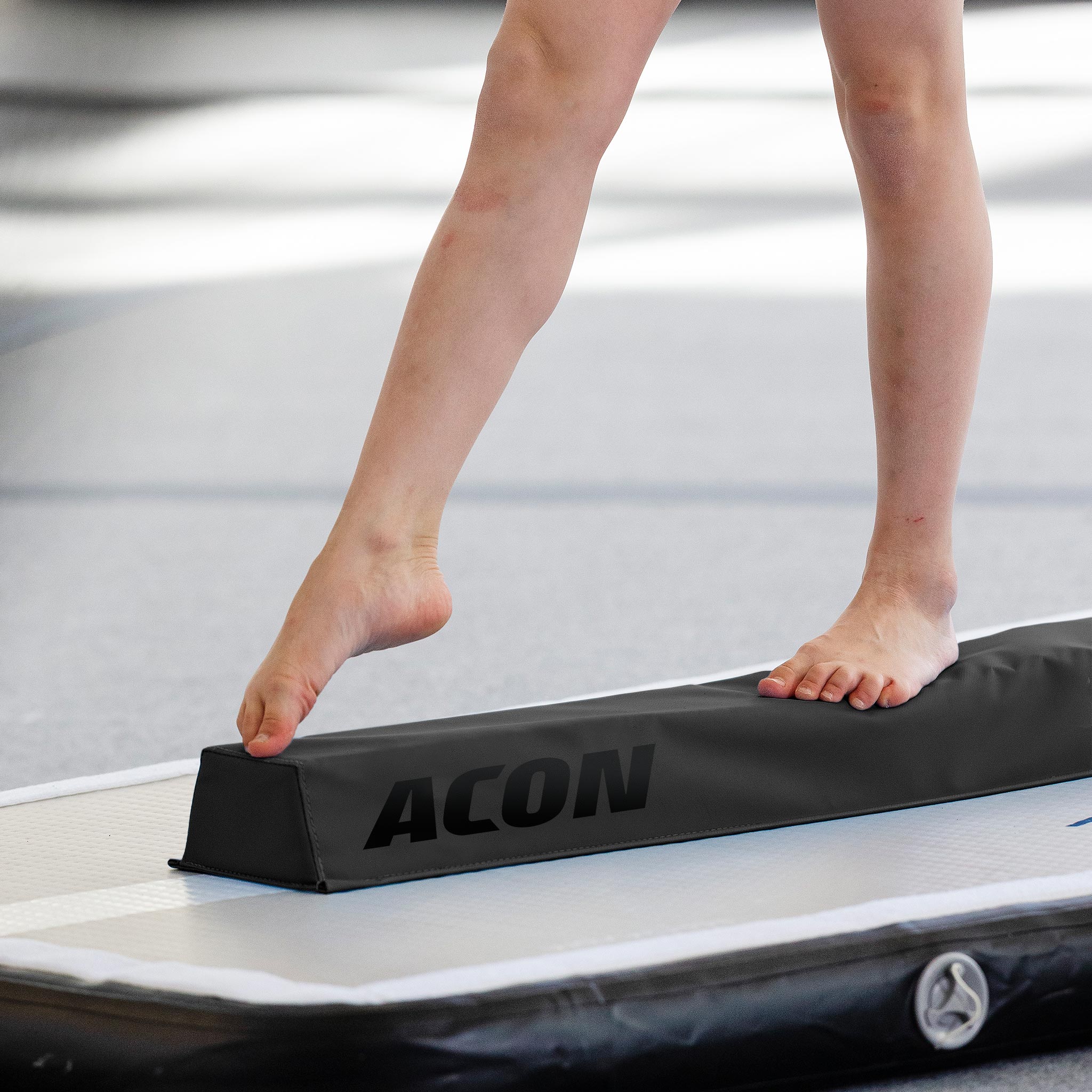 Detalj av gymnastens ben med ACON-gymnastikbom.