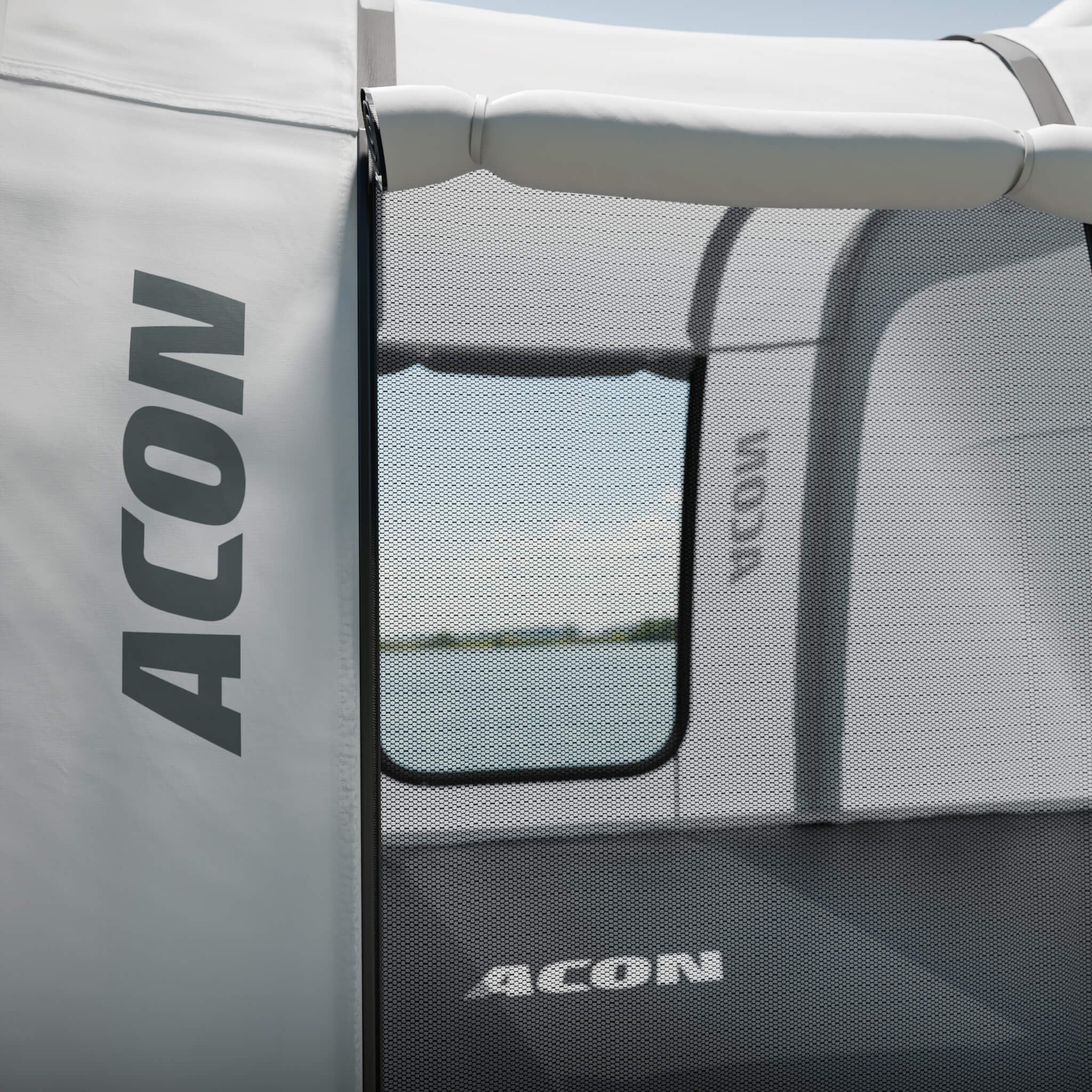 Närbild av ingången till Acons trampolintält, med Acon-logotypen på en vit tygpanel.