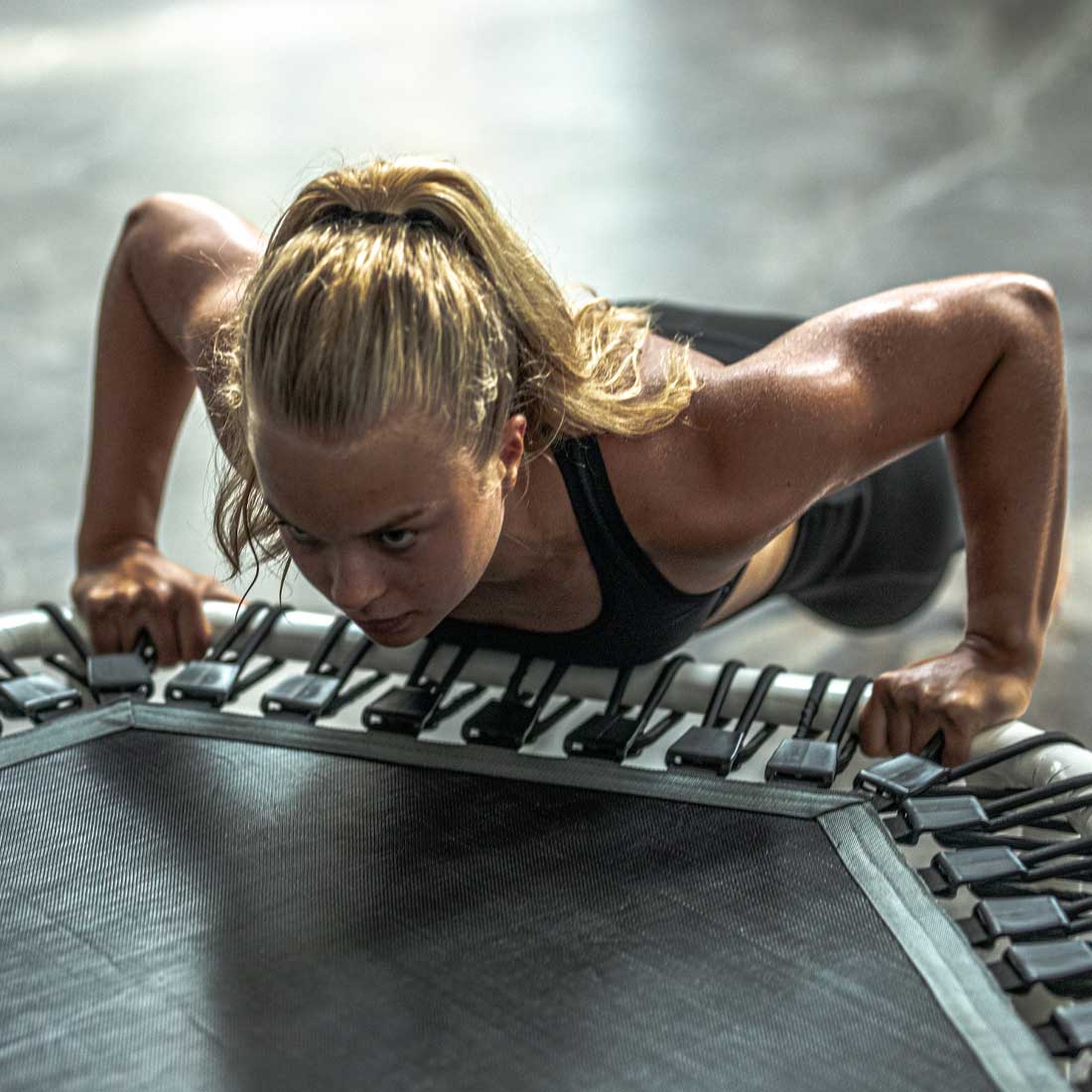 Kvinna tränar på Acon FIT 1,41 m vit Hexagon-trampolin.