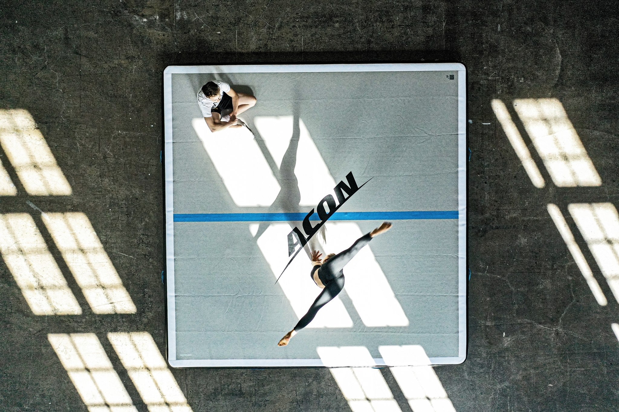 En kvinnlig gymnast gör volter på en Acon Big Airtrack.